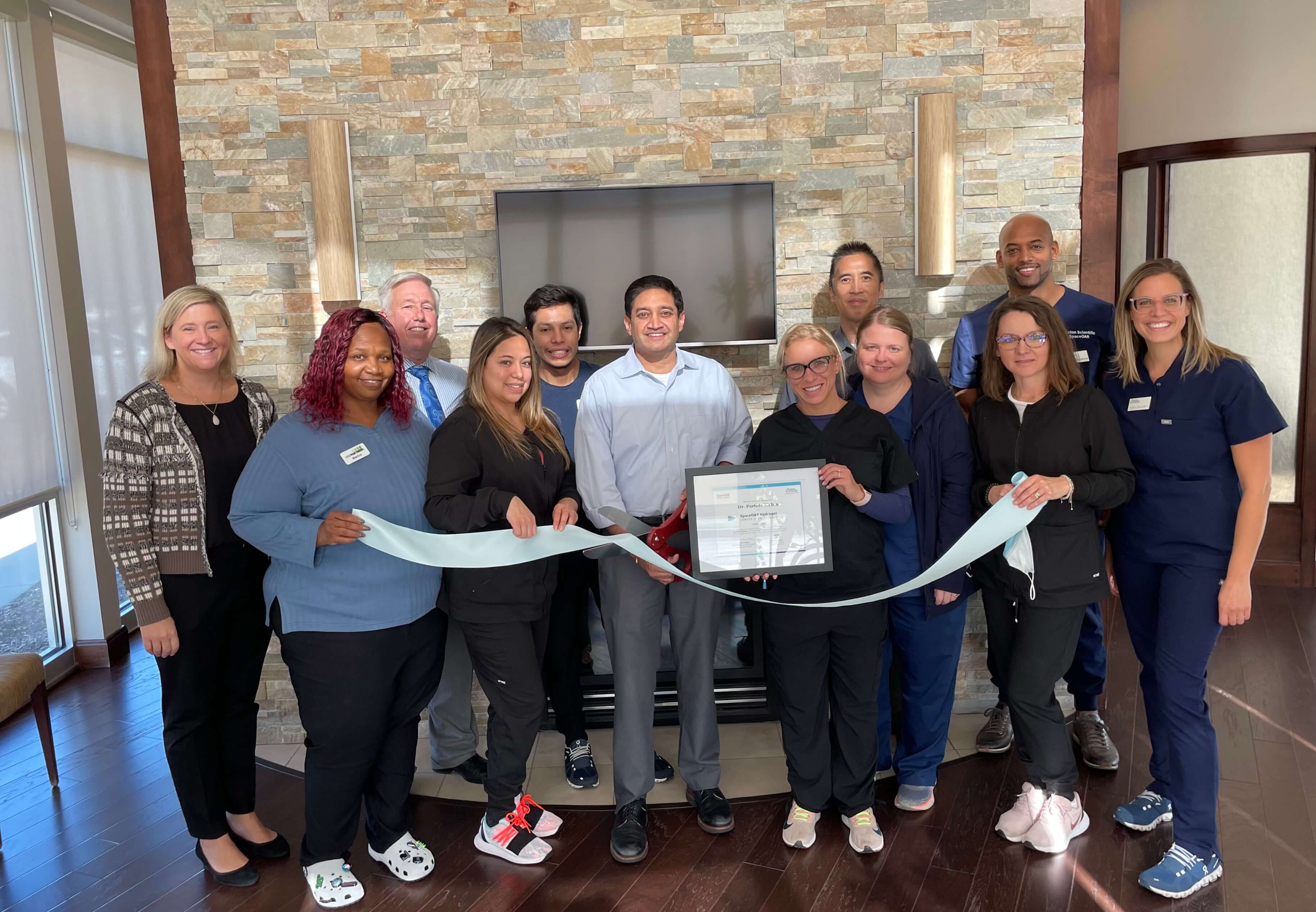 Mehta Group Photo with Ribbon Cutting.jpg